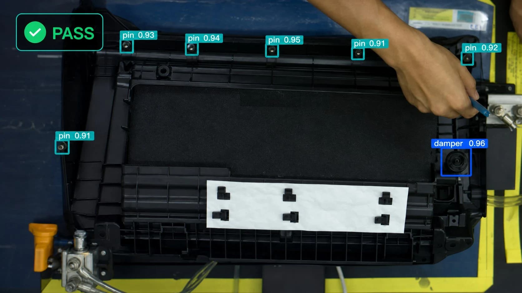 Inspection view with a PASS verdict and detection boxes on a part